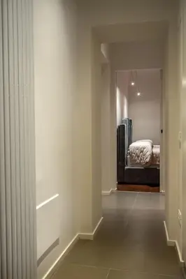 a hallway with a mirror and a bed in a bedroom at Gracchi39 Apartment in Rome