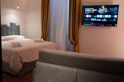 a bedroom with a bed and a tv on the wall at Gracchi39 Apartment in Rome