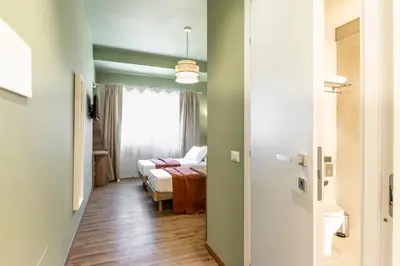 a room with a bed and a bedroom with a window at Notte Ai Colli - Rooms & Kitchen in Rome