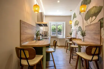a restaurant with tables and chairs and a kitchen at Notte Ai Colli - Rooms & Kitchen in Rome