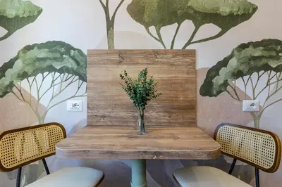 a wooden table with a vase of flowers on it at Notte Ai Colli - Rooms & Kitchen in Rome