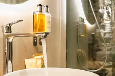 a bathroom with a sink and a bottle of soap at Notte Ai Colli - Rooms & Kitchen in Rome