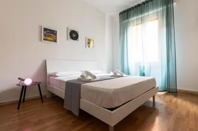 a white bedroom with a bed and a window at Cappuccino Pop, Apartment Metro A in Rome