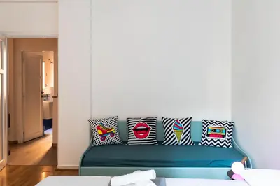 a living room with a blue couch with pillows at Cappuccino Pop, Apartment Metro A in Rome