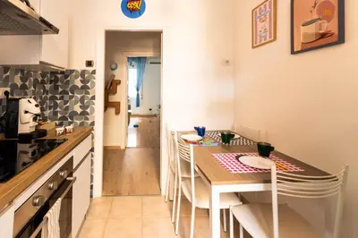 a kitchen with a table and chairs in a room at Cappuccino Pop, Apartment Metro A in Rome