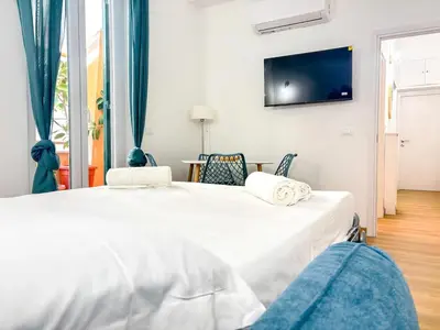 a bedroom with a bed and a tv on the wall at Modern apartment with Private Balcony Near Colosseum in Rome