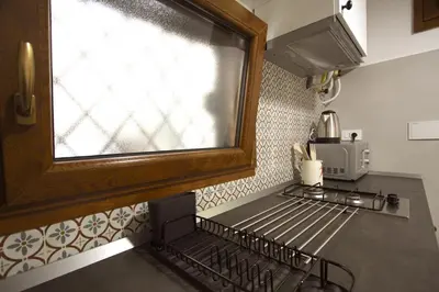 a kitchen with a window above a kitchen stove at Serpenti Holiday House in Rome