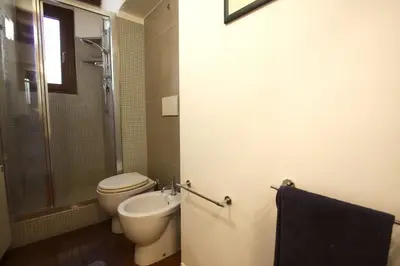 a bathroom with a toilet and a shower and a sink at Serpenti Holiday House in Rome