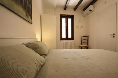 a bedroom with a bed and a chair and a window at Serpenti Holiday House in Rome