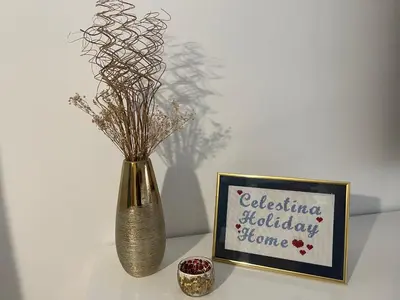 a vase with dried flowers in it next to a picture at Celestina Holiday Home Policlinico Gemelli in Rome