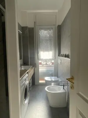 a white bathroom with a toilet and a sink at Celestina Holiday Home Policlinico Gemelli in Rome