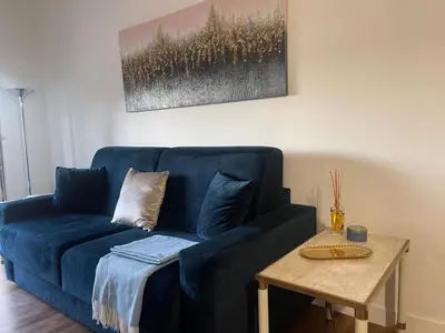 a blue couch in a living room with a table at Celestina Holiday Home Policlinico Gemelli in Rome