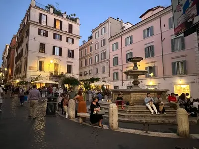 a group of people sitting around a fountain in a city at Anna Stellarum in Rome