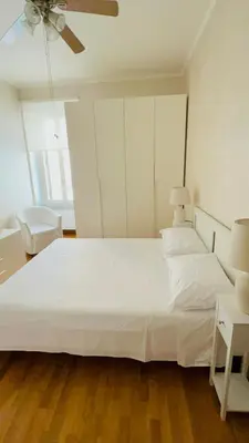 a bedroom with a large white bed and a ceiling fan at Anna Stellarum in Rome