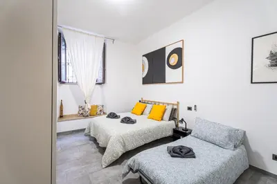 a bedroom with two beds and a couch at Sallustiano - Porta Pia - Rooms in Rome