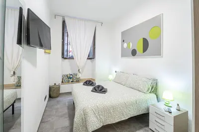 a white bedroom with a bed and a tv at Sallustiano - Porta Pia - Rooms in Rome