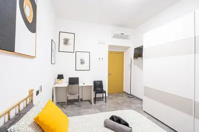 a living room with a desk and a yellow door at Sallustiano - Porta Pia - Rooms in Rome