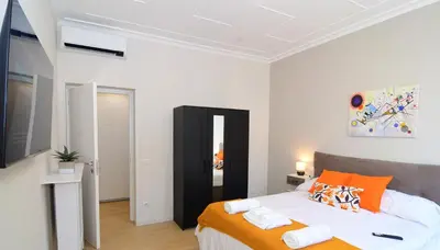 a bedroom with a large bed with orange pillows at San Giovanni Suite Rome in Rome