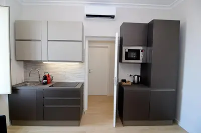 a kitchen with gray cabinets and a sink and microwave at San Giovanni Suite Rome in Rome