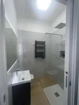 a white bathroom with a sink and a shower at San Giovanni Suite Rome in Rome