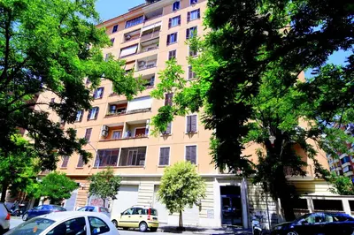 a large building with cars parked in front of it at San Giovanni Suite Rome in Rome