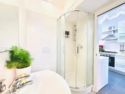 a white bathroom with a shower and a sink at San Giovanni Lulus Home in Rome