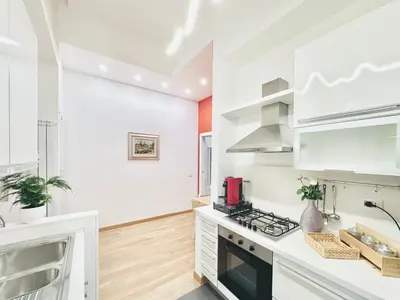 a kitchen with white cabinets and a stove at San Giovanni Lulus Home in Rome