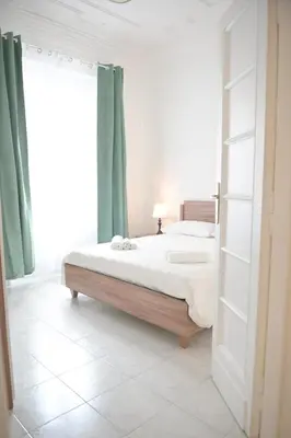 a bedroom with a large bed with green curtains at Tasso 39 in Rome