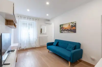 a living room with a blue couch and a television at Ponte Milvio-Olympic Stadium Modern Apartment in Rome