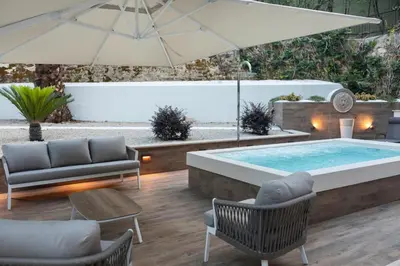 a swimming pool with an umbrella and chairs and a patio at Pool & Spa Deluxe in Rome