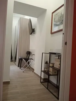 a hallway with a table and a chair in a room at Laterano 190 apt at Colosseo in Rome
