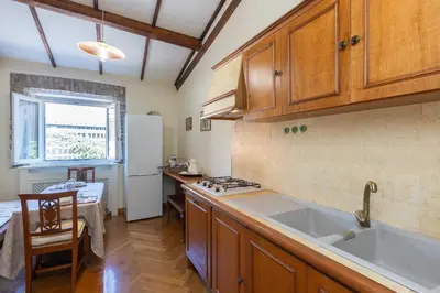 a kitchen with wooden cabinets and a sink and a table at Monti Atmosphere Apartment by Rental in Rome in Rome