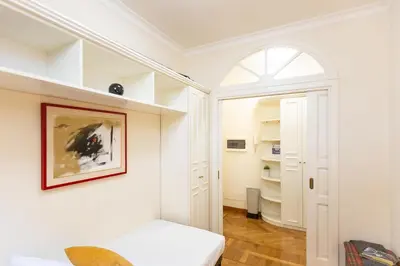 a white room with a bed and an arched window at Monti Atmosphere Apartment by Rental in Rome in Rome