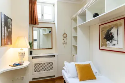 a living room with a white chair and a mirror at Monti Atmosphere Apartment by Rental in Rome in Rome
