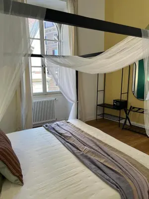 a bed with a canopy in a room with a window at Eufonia Vatican Golden Suites in Rome