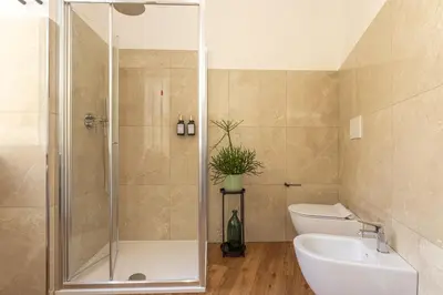 a bathroom with a shower and a toilet and a sink at Eufonia Vatican Golden Suites in Rome