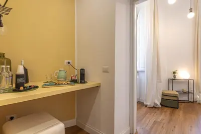 a bathroom with a toilet and a table and a window at Eufonia Vatican Golden Suites in Rome
