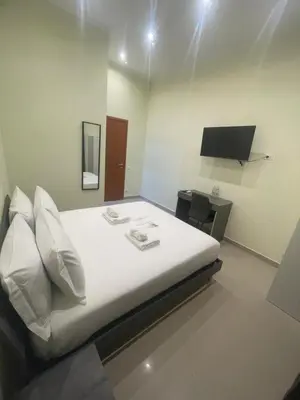 a bedroom with a large white bed with a desk at Rome jubilee stays 2 in Rome