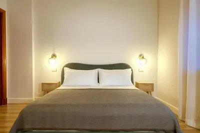a bedroom with a large bed with two lights on the wall at Sole 34 Apartment in Rome