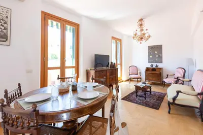 a living room with a wooden table and chairs at Casa Arezzo - silenzioso trilocale con terrazzino privato - Cale 06 in Rome