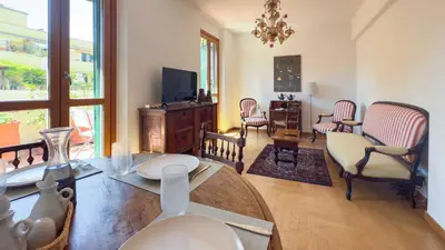a living room with a table and chairs at Casa Arezzo - silenzioso trilocale con terrazzino privato - Cale 06 in Rome