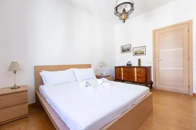 a bedroom with a large white bed and a dresser at Casa Arezzo - silenzioso trilocale con terrazzino privato - Cale 06 in Rome