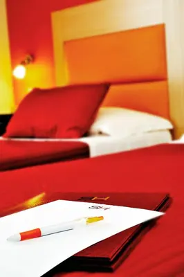 a pen and paper on a table next to a bed at Hotel Scott House in Rome
