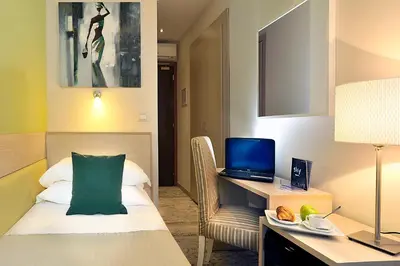 a hotel room with a bed and a desk with a computer at Hotel Scott House in Rome