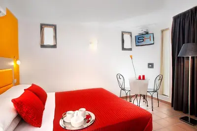 a bedroom with a red bed and a table and chairs at Hotel Scott House in Rome