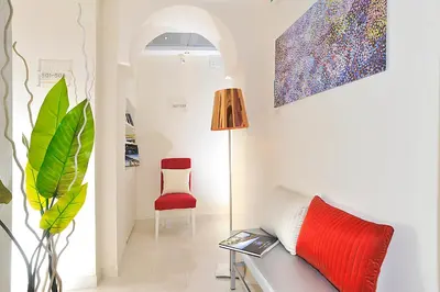a living room with a couch and a red chair at Hotel Scott House in Rome