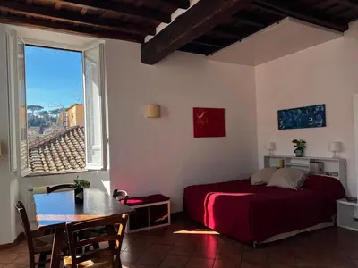 a bedroom with a bed and a table and a window at Finestre sul Tevere in Rome