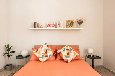 a bedroom with an orange bed with two pillows at Maggiore Home in Rome