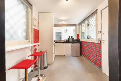 a kitchen with red tiles and red stools at Quintino Terrace Apartment near Termini Station in Rome