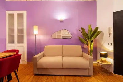 a living room with a couch and a purple wall at Quintino Terrace Apartment near Termini Station in Rome